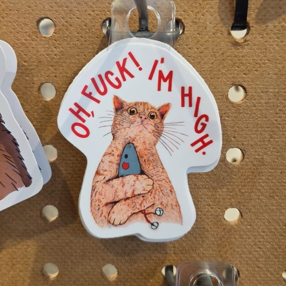 Sticker of a cat holding a fish stating, "Oh, fuck! I'm high."